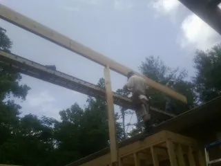Carpenter setting a ridge beam over a new addition frame — Ice Dam Removal by Roofing Brothers in Bartonsville